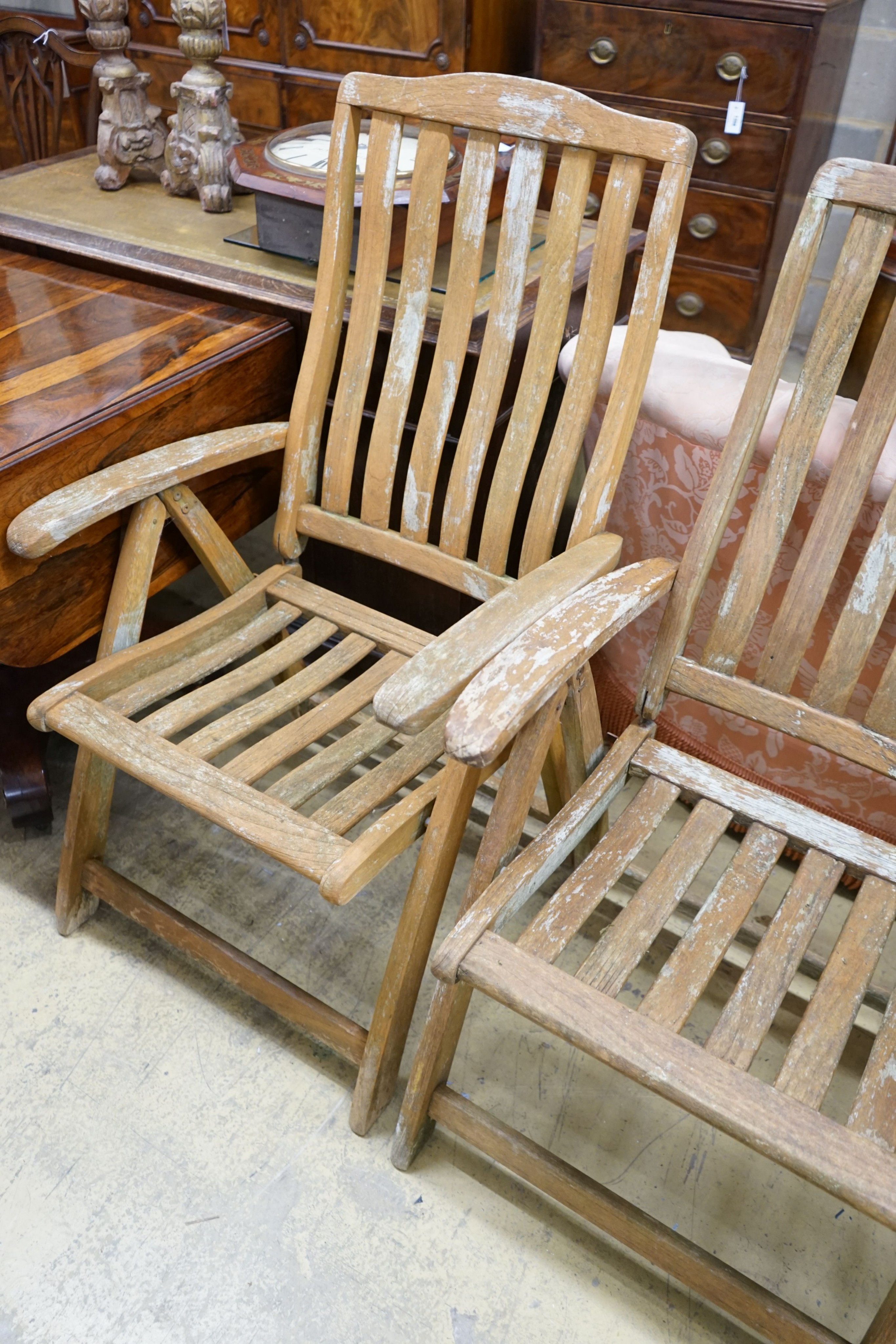 A set of four weathered teak folding garden armchairs, width 63cm, depth 56cm, height 114cm